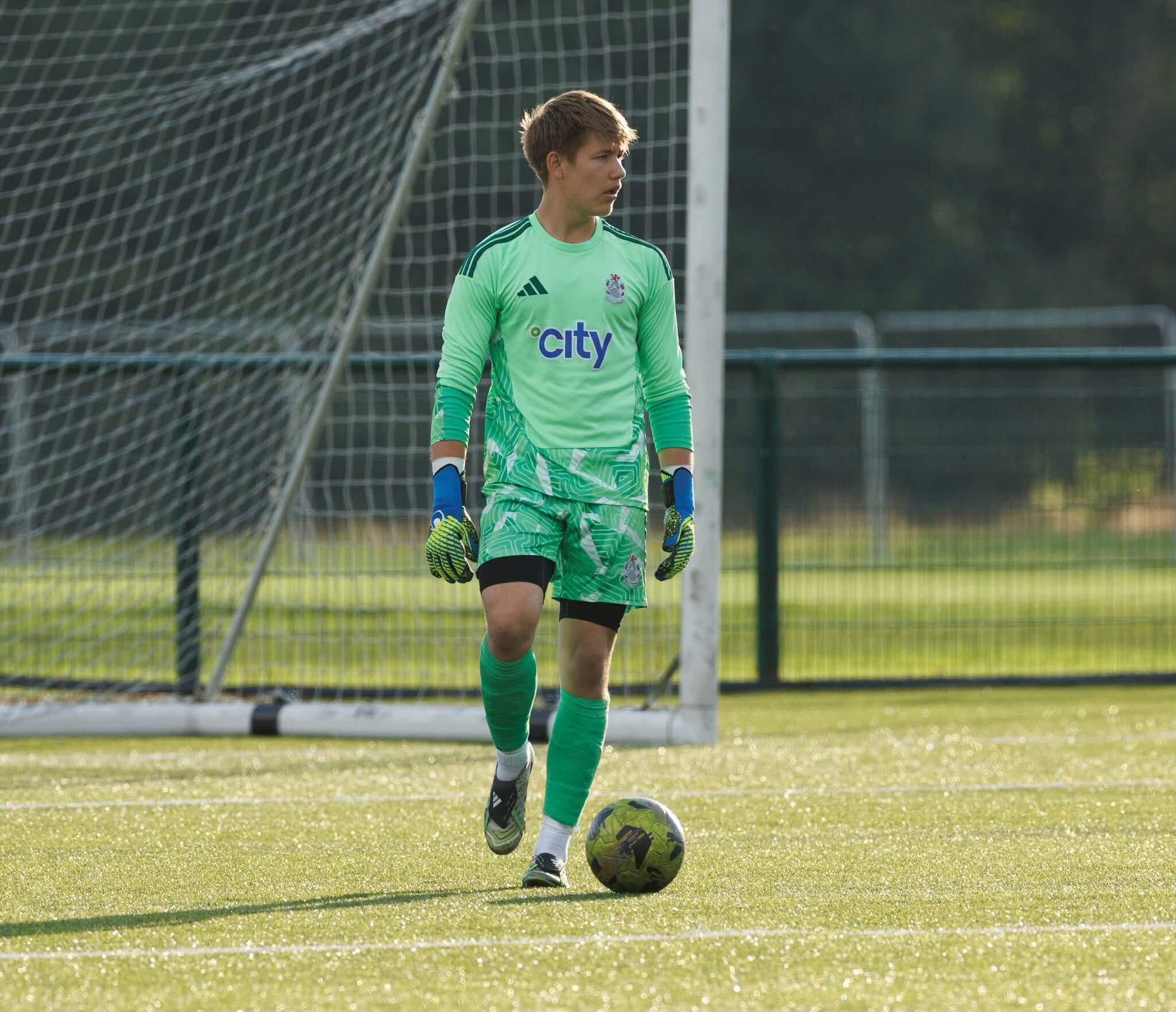 Football goalkeeper prepared to defend a striker's shot. Specialist sports physiotherapy Glasgow supports explosive dynamics and a safe range of motion on the pitch.